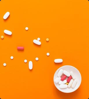 Different pills on orange table